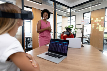 Diverse group of business colleagues using vr headset in meeting room