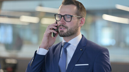 Portrait of Middle Aged Businessman Talking on Phone
