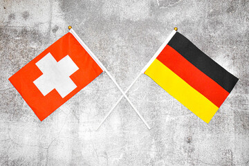 Hand flags of Germany and Switzerland on Abstract background