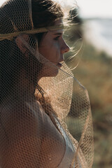 Close-up A beautiful girl in a stilted suit sits on a mountain above the sea, a lake on a sunny day.