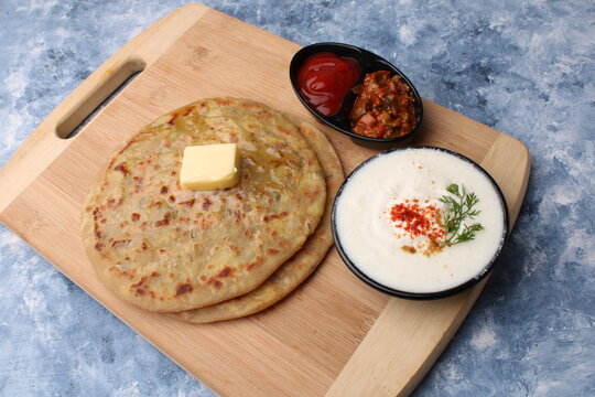 Traditional Indian food Aloo paratha or potato stuffed flat bread. served with pickle  tomato ketchup and curd, 