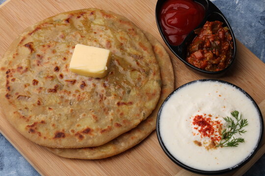 Traditional Indian food Aloo paratha or potato stuffed flat bread. served with pickle  tomato ketchup and curd, 