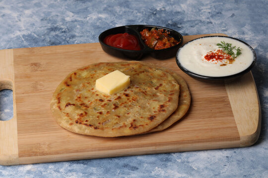 Traditional Indian food Aloo paratha or potato stuffed flat bread. served with pickle  tomato ketchup and curd, 