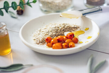 Home cosmetic mask for face skin from natural ingredients of fresh berries, oatmeal, honey, essential oils. Ingredients for making handmade natural cosmetics, flat lay, copy space 