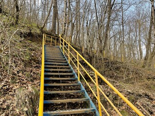 Close up of metal staircase in woodland. Metal stairway to overcome obstacles in mountainous terrain.