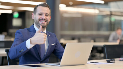 Thumbs Up by Middle Aged Businessman with Laptop at Work 
