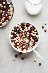 Cereal chocolate balls in bowl with milk.