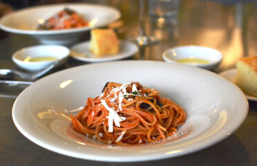 イタリア料理店の、チーズのかかったトマトのスパゲッティ。