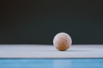 Cork massage ball for fascia on a cork yoga mat, on a black background. Concept: eco friendly and biodegradable props for self care at home
