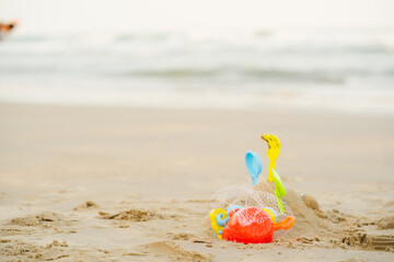 Children toys group on the summer beach and sand for holiday and vacations. Plastic toy bucket and sandbox molds. on beach and sea background.