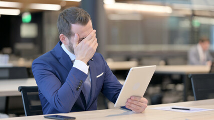 Middle Aged Businessman Upset by Loss on Tablet 
