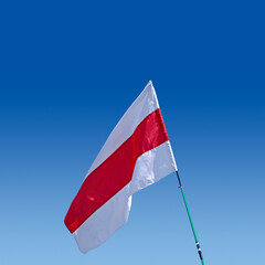 Isolated waving Belarusian national flag on blue sky background. White-red-white flag. A symbol of...