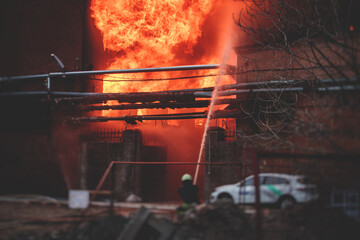 Firefighters put out large massive fire blaze, group of fire men in uniform during fire fighting...