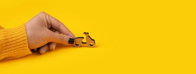 delivery scooter in hand over yellow background, panoramic mock-up with space for text