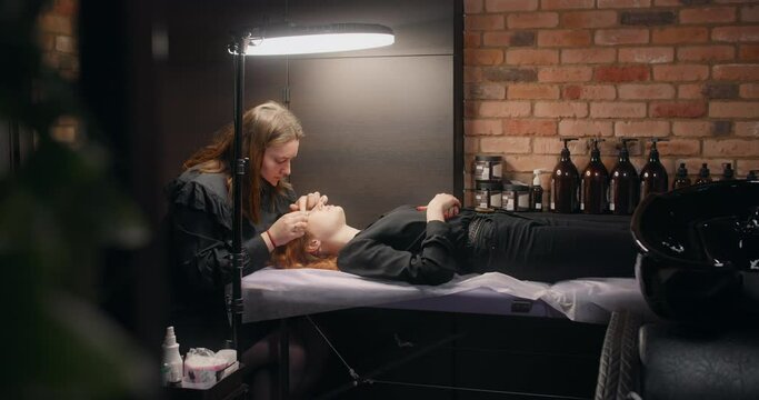 Lashmaker does the eyelash lamination procedure for the client in the beauty salon, cosmetic services, beauty care procedures, 4k 60p Prores HQ