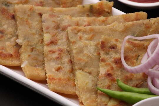 Traditional Indian food Aloo paratha or potato stuffed flat bread. served with pickle  tomato ketchup and curd, butter, onion chili.