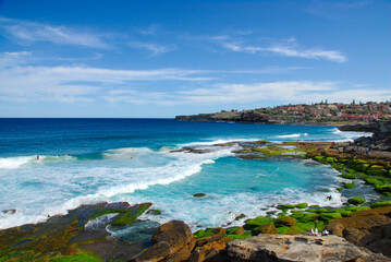 Fototapeta na wymiar Surfers and swimmers enjoying a beautiful summer day at Tamarama and Bronte beaches in New South Wales, Australia.