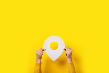 white map pointer 3d pin, location symbol in hand over yellow background