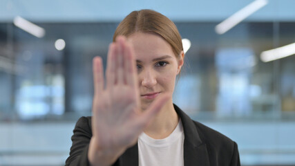 Fototapeta premium Portrait of Woman Showing Stop Sign by Hand 