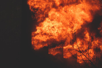 Massive large blaze fire in the city, brick factory building on fire, hell major fire explosion flame blast,  with firefighters team firemen on duty, arson, burning house damage destruction