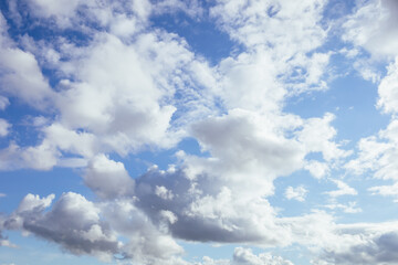 Soft and fluffy clouds formation on the bright sunny blue sky. Nature abstract background. Fresh air, weather concept