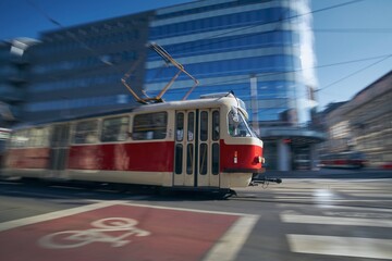 Tram of public transportation in blurred motion against crossroad. Daily life in city. Prague, Czech Republic.