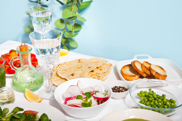 Spring fresh salad with radish and basil on the dinner table with pita flat bread