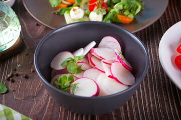 Spring fresh salad with radish and basil on the dinner table
