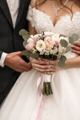 Wedding bouquet with fresh natural flowers in the hands of the bride