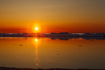 Obraz premium Beautiful winter sunset by the sea with iceberg