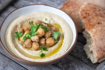 Classic hummus with parsley on a plate and pita bread.