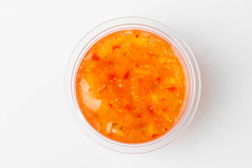Small cup of sweet and sour sauce, top view on white background