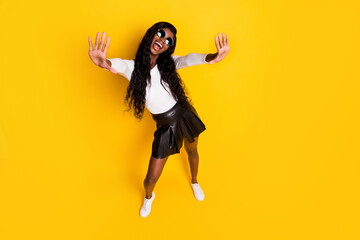 High angle view on cheerful black skinned woman waving hand laughing meeting isolated on vivid yellow color background
