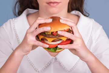 Huge and juicy burger being held by a female