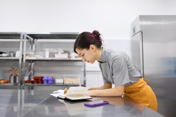 The pastry chef girl makes notes in a notebook