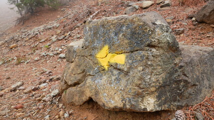 An arrow on the stone indicates the direction of the hiking trail and direction of travel.