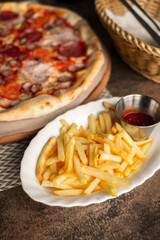 Pizza on the table with dishes and oils and french fries, Italian cuisine. Fried french fries. restaurant service. Food.