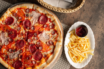 Pizza on the table with dishes and oils and french fries, Italian cuisine. Fried french fries. restaurant service. Food.