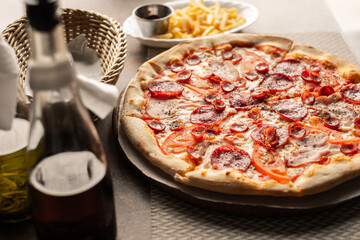 Pizza on the table with dishes and oils and french fries, Italian cuisine. Fried french fries. restaurant service. Food.