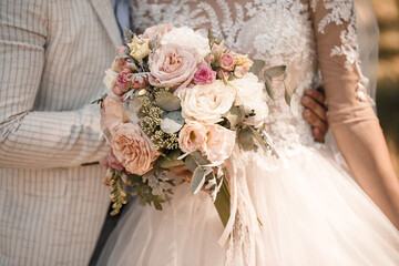 Wedding bouquet with fresh natural flowers in the hands of the bride