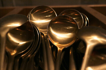 Shiny brass spoons in a pile