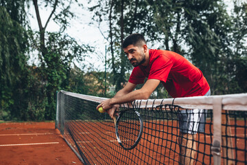 exhausted tennis player leaned on net © cherryandbees