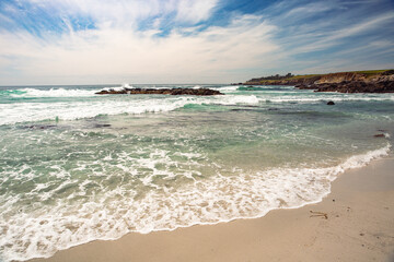 The Pacific Ocean coast in the city of Monterey in California. United States of America. Beautiful beach on a sunny day. Ocean landscape.