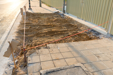 Installing paving bricks in pedestrian zone. Laying paving slabs at construction site on walkway, stacked tile on background. Repairing pavement, laying paving slabs at construction site on walkway.