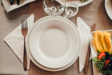White empty plate with fork and knife isolated on white