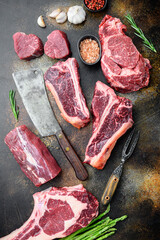 Variety of raw beef meat steaks for grilling with seasoning and utensils, tomahawk, t bone, club...