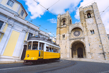 Lisbon city and famous yellow tram 28 in front of Santa Maria cathedral on a sunny summer day. Trams in Lisbon, Portugal. Tourist attraction - obrazy, fototapety, plakaty