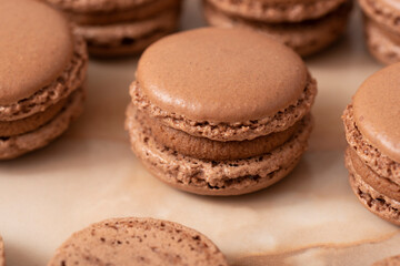 brown macarons with chocolate cream, on a wooden table