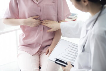 Doctor checking patient's stomachache in office