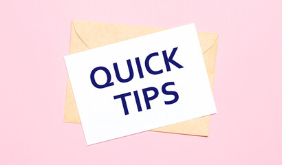 On a light pink background - a craft envelope. It has a white sheet of paper that says QUICK TIPS.